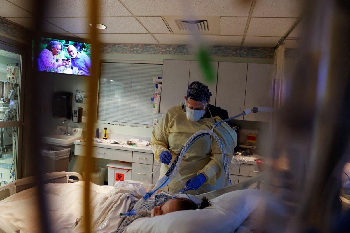 Medical staff treat a COVID-19 patient in their isolation room in the intensive care unit at Western Reserve Hospital in Cuyahoga Falls, Ohio on Jan. 5, 2022. (Shannon Stapleton/Reuters)