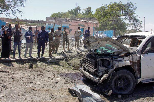 Security forces and others look at the remains of an armored vehicle struck by a blast in Mogadishu, Somalia, on Jan. 12, 2022. (Farah Abdi Warsameh/AP Photo)