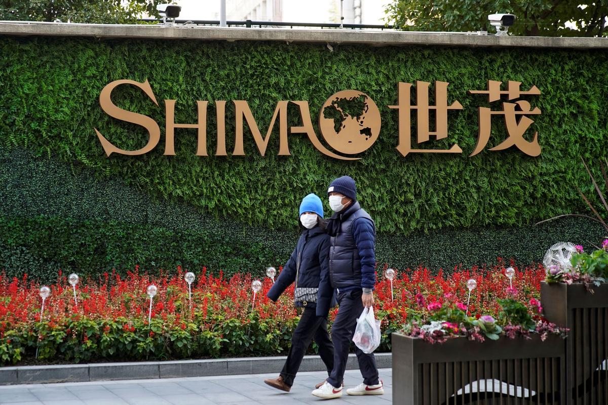 People walk past the logo of property developer Shimao Group near Shimao Tower in Shanghai, China, on Jan. 13, 2022. (Aly Song/Reuters)