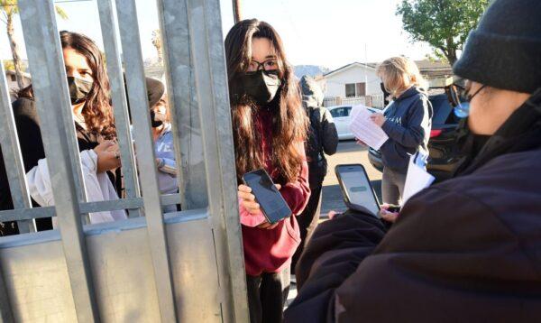A student shows her negative COVID-19 test result from her cellphone for entry to Olive Vista Middle School on the first day back in Sylmar, Calif., on Jan. 11, 2022. (Frederic Brown/AFP via Getty Images)
