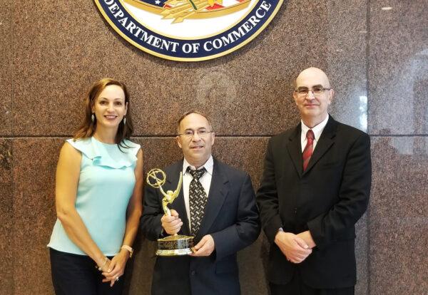 Glenn Sanders (center), Gregory Gonsalves, his lead patent counsel, and Rita Chipperson, his patent prosecution counsel, pose with their Emmy Award at the US Patent Office in August 2019. (Courtesy of US Inventor)