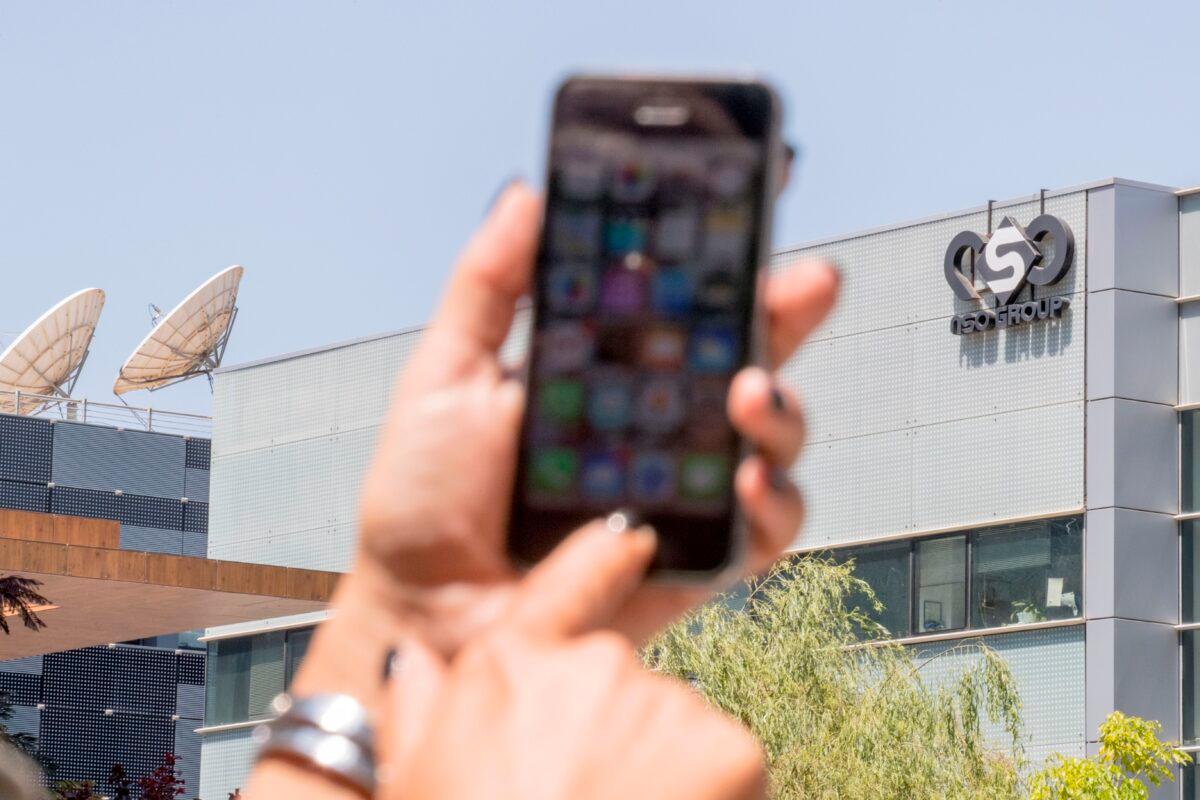 An Israeli woman uses her iPhone in front of the building housing the Israeli NSO group, in Herzliya, near Tel Aviv, Israel, on Aug. 28, 2016. (Jack Guez/AFP via Getty Images)