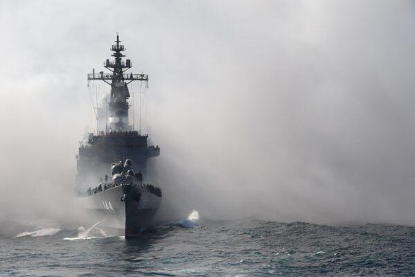 Japan's Maritime Self-Defense Force (MSDF) escort ship Kurama sails through smoke during a fleet review off Sagami Bay, Kanagawa Prefecture, Japan, on Oct. 18, 2015. Thirty-six MSDF vessels and navy ships from Australia, India, France, South Korea and the United States participated in the fleet review. (Toru Yamanaka/AFP via Getty Images)