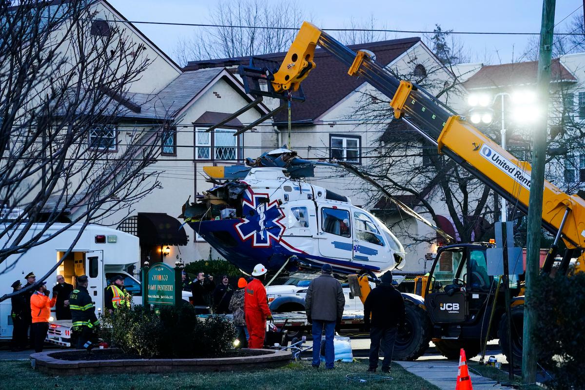 A crashed medical helicopter is removed from the scene in the Drexel Hill section of Upper Darby, Pa., on Wednesday, Jan. 12, 2022. (Matt Rourke/AP Photo)