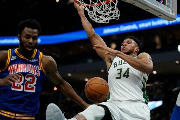 Milwaukee Bucks' Giannis Antetokounmpo dunks past Golden State Warriors' Andrew Wiggins during the second half of an NBA basketball game, in Milwaukee, on Jan. 13, 2022. (Morry Gash/AP Photo)