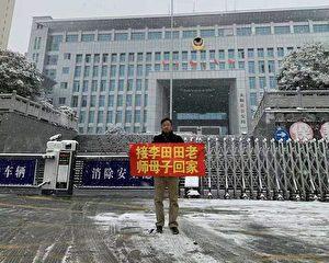 Lawyer Xie Yang pulls a banner in front of the Public Security Bureau of Yongshun County, Hunan Province, on Dec. 25, 2021. The banner reads: “Bring teacher Li Tiantian and her baby home.” (Provided by Chen Guiqiu)