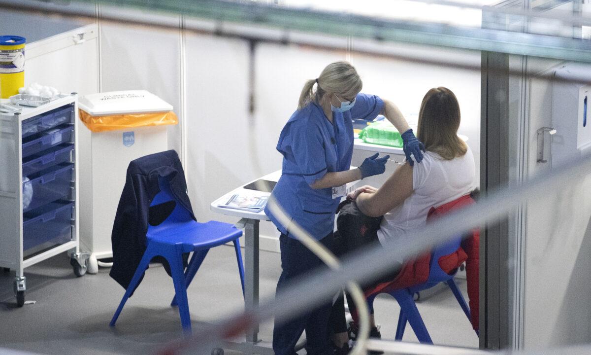 A nurse administers a CCP virus vaccine to a health and care staff member at the NHS Louisa Jordan Hospital in Glasgow, Scotland, on Jan. 23, 2021. (Jane Barlow/PA)