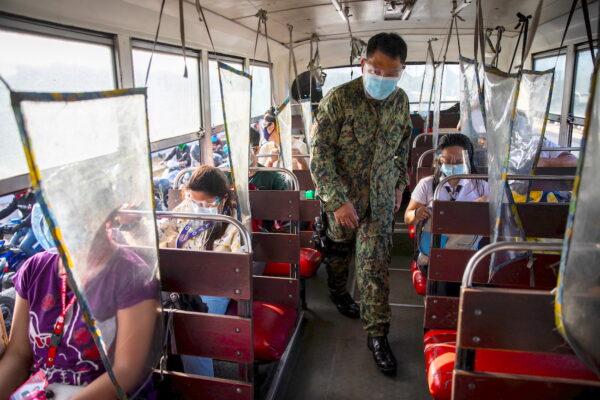 A policeman on a bus in Quezon City, Metro Manila, Philippines, on Aug. 6, 2021. (Eloisa Lopez/Reuters)