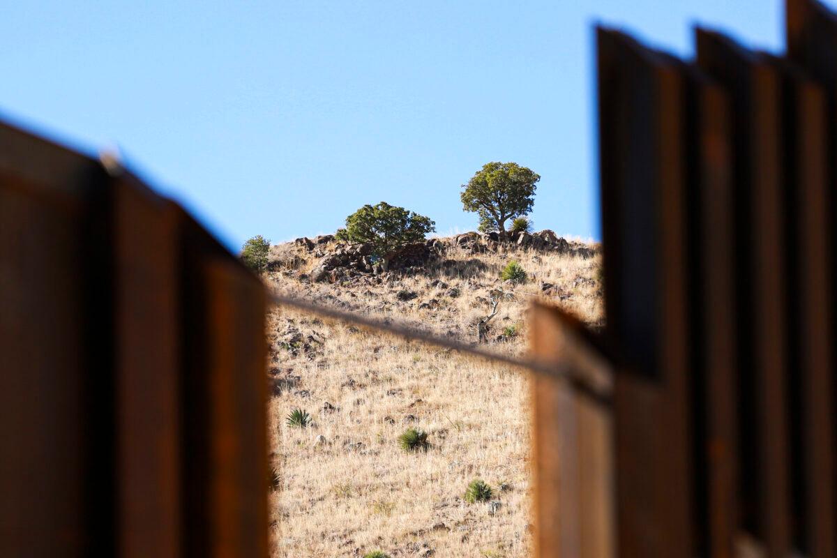 A cartel scout’s campsite can be seen below a tree on the Mexican side of the border wall near Naco in Cochise County, Ariz., on Dec. 6, 2021. (Charlotte Cuthbertson/The Epoch Times)
