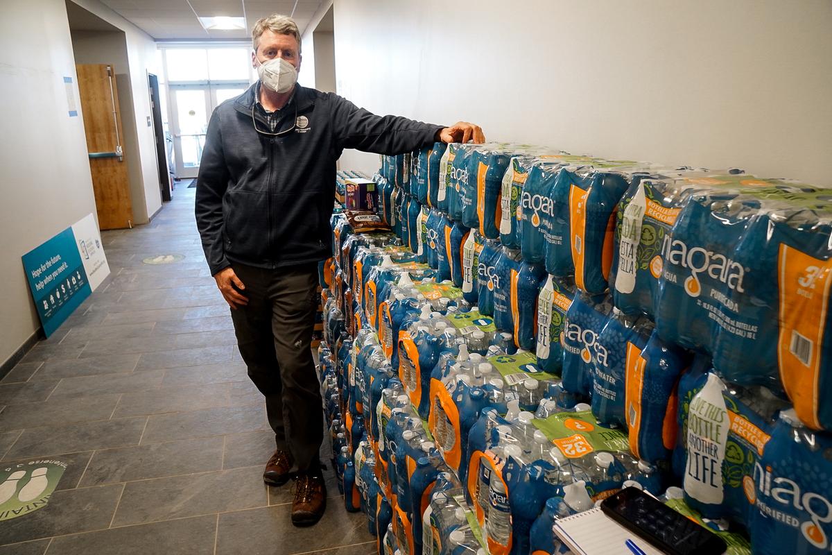 Boulder County Disaster Recovery Manager Garry Sanfacon displays on Jan. 11, 2022, the hundreds of bottles of water that were donated for the victims of the Marshall fire that ripped through East Boulder County, Colo., on Dec. 30, 2021. (Allan Stein/The Epoch Times)