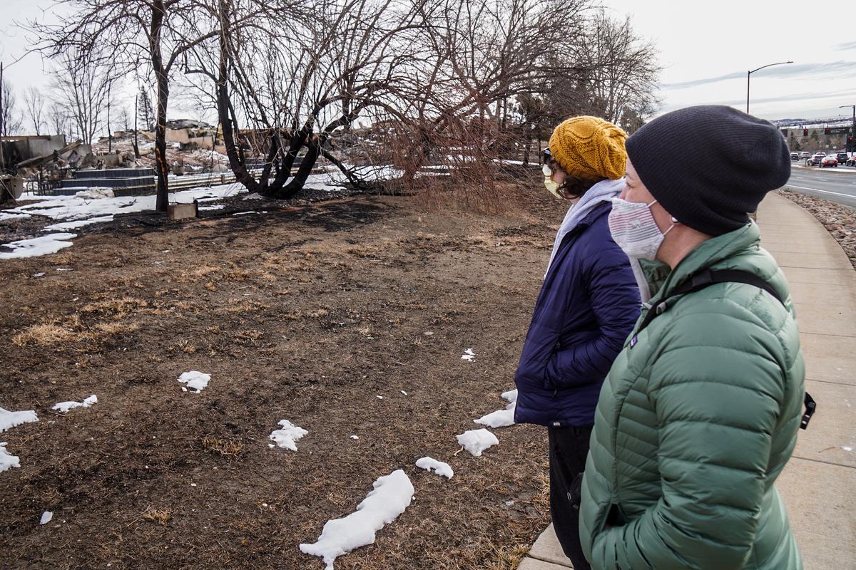 Tara Dunn, right, and Callie Paul survey the remains of a subdivision that was destroyed by a fast-moving wildfire in East Boulder County, Colo., on Dec. 30, 2021. (Allan Stein/The Epoch Times)