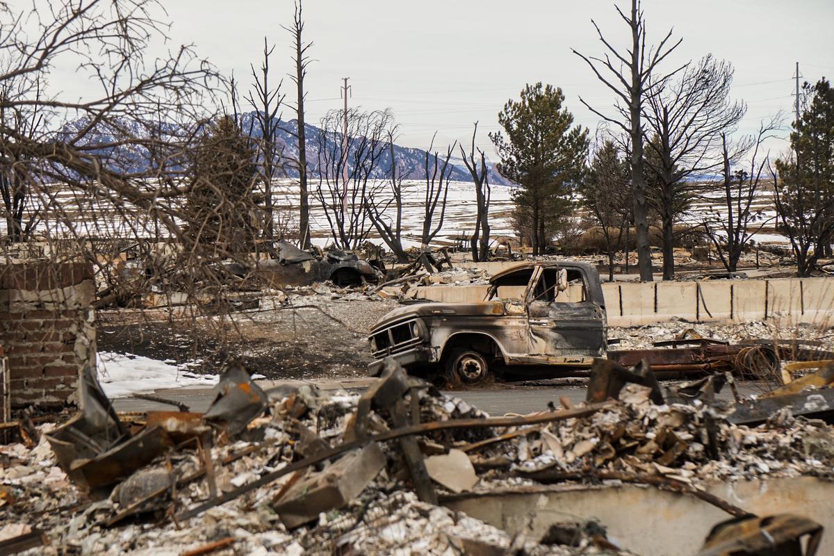 A burned truck tilts precariously on Jan. 12, 2022, in the Sagamore subdivision in Superior, Colo., which suffered much of the damage caused by the Marshall fire. (Allan Stein/The Epoch Times)
