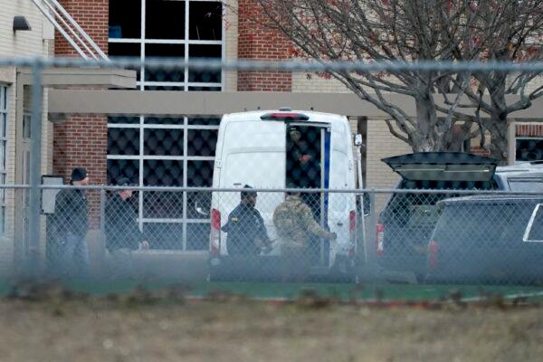 Law enforcement officials gather at Colleyville Elementary School near the Congregation Beth Israel synagogue in Colleyville, Texas, on Jan. 15, 2022. (AP Photo/Tony Gutierrez)