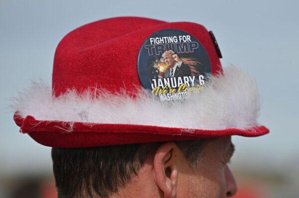 A supporter wears a large button reading "Fighting for President Trump, January 6 We're Coming" on his hat as he attends the first rally of the year by former President Donald Trump at the Canyon Moon Ranch festival grounds in Florence, Ariz., on Jan. 15, 2022. (Robyn Beck/AFP via Getty Images)