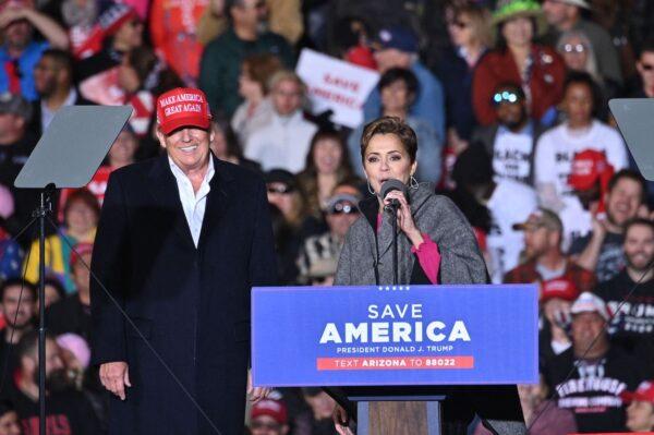 Former President Donald Trump and Kari Lake, whom Trump is supporting in the Arizona gubernatorial race, share the stage during a rally at the Canyon Moon Ranch festival grounds in Florence, Arizona, on Jan. 15, 2022. (Robyn Beck/AFP via Getty Images)