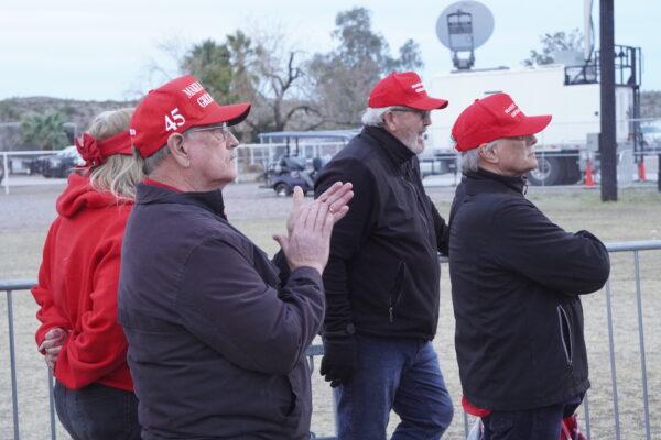 Donald Trump supporters wearing MAGA hats applaud a guest speaker at a 2022 Save America rally in Florence, Ariz., on Jan. 15, 2022. (Allan Stein/The Epoch Times)