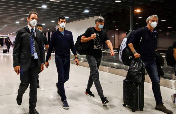 Serbian tennis player Novak Djokovic (2nd L) walks in Melbourne Airport before boarding a flight, after the Federal Court upheld a government decision to cancel his visa to play in the Australian Open, in Melbourne, Australia, on Jan. 16, 2022. (Loren Elliott/Reuters)