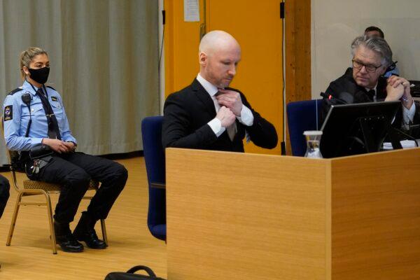 Norwegian mass killer Anders Behring Breivik, center, adjusts his tie as he is flanked by his defense lawyer Oystein Storrvik, right, on the first day of a hearing where he is seeking parole, in Skien, Norway, on Jan. 18, 2022. (Ole Berg-Rusten/NTB scanpix via AP)