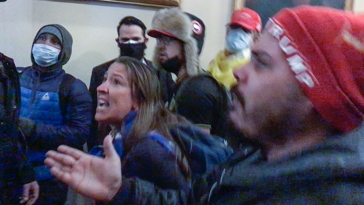 Ashli Babbitt pleads with police to call for backup at the Speaker's Lobby doors at the U.S. Capitol on Jan. 6, 2021. The man at right complains the crowd is not being let into the House of Representatives. (Video Still / ©Tayler Hansen)