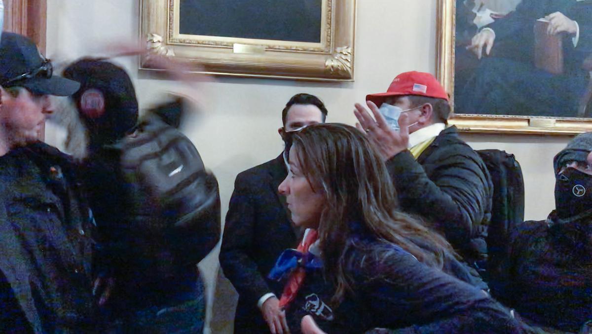 Ashli Babbitt watches as rioter Zachary Alam punches the glass in the door of the Speaker's Lobby at the U.S. Capitol on Jan. 6, 2021. (Video Still / ©Tayler Hansen)