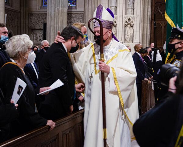 Cardinal Timothy Dolan, archbishop of the Archdiocese of New York, greets Lt. Conor McDonald at the memorial mass for his father, Det. Steven McDonald, at St. Patrick’s Cathedral in NYC on Jan. 18, 2022. (Dave Paone/The Epoch Times)