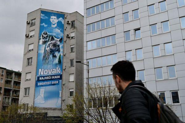 A pedestrian walks past a billboard depicting Serbian tennis player Novak Djokovic displayed on the facade of a building above his restaurant, in Belgrade, Serbia, on Jan. 6, 2022. (Andrej Isakovic/AFP via Getty Images)