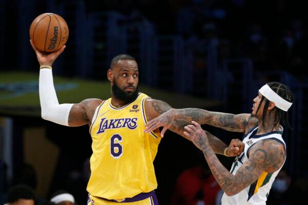 Los Angeles Lakers forward LeBron James (6) is defended by Utah Jazz guard Jordan Clarkson, right, during the first half of an NBA basketball game in Los Angeles on Jan. 17, 2022. (AP Photo/Ringo H.W. Chiu)