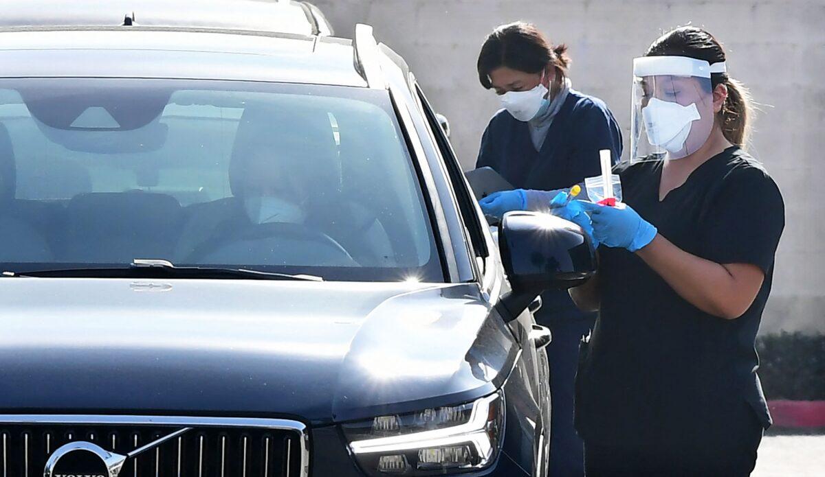 People get tested inside their vehicles at a COVID-19 testing station in Monterey Park, Calif., on Jan. 14, 2022. (Frederic J. Brown/AFP via Getty Images)