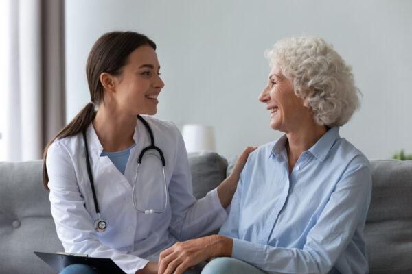 A healthcare worker interacts with a patient in her home. (Shutterstock)