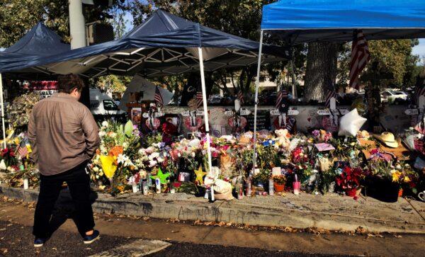 A passerby stops to look over a street side memorial to the shooting victims of the Borderline Bar in Thousand Oaks, Calif., on Nov. 27, 2018. (Amanda Lee Myers/AP Photo)