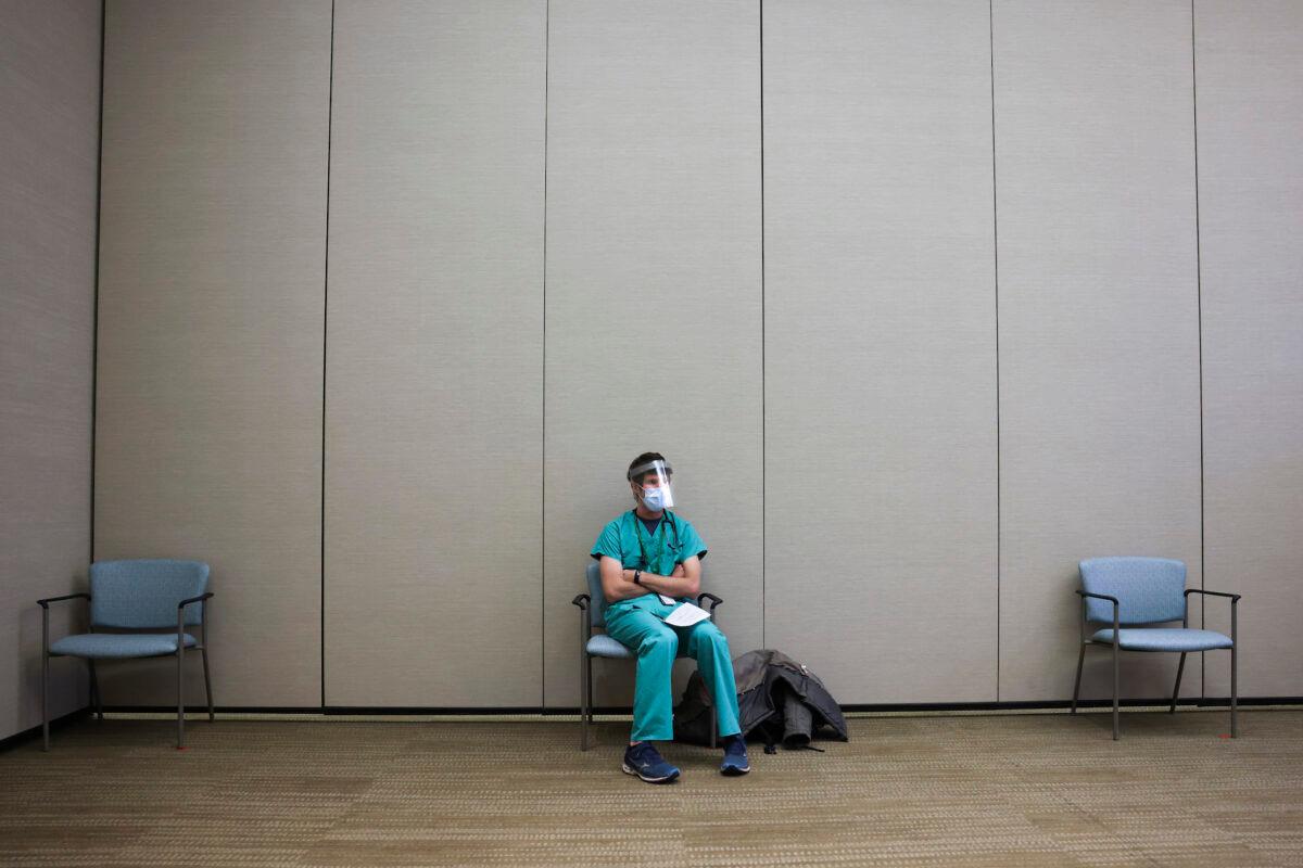 An internal medicine resident sits in a waiting area before receiving a dose of the Pfizer-BioNTech COVID-19 vaccine at a hospital in Aurora, Colorado, on Dec. 16, 2020. (Michael Ciaglo/Getty Images)