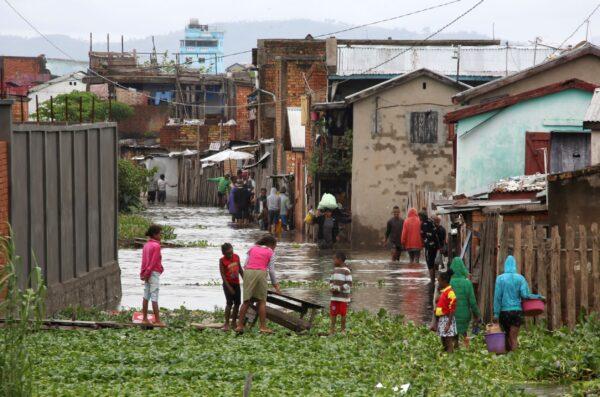 Residents wade through flood water around their homes after heavy rain in Antananarivo, Madagascar, on Jan. 19, 2022. (Alexander Joe/AP Photo)