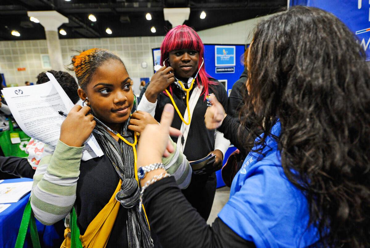 A transgender high school student (C) and classmate (L) visit the Children's Hospital Los Angeles booth during a college and career convention at the Los Angeles Convention Center in Los Angeles on December 8, 2010. (Kevork Djansezian/Getty Images)