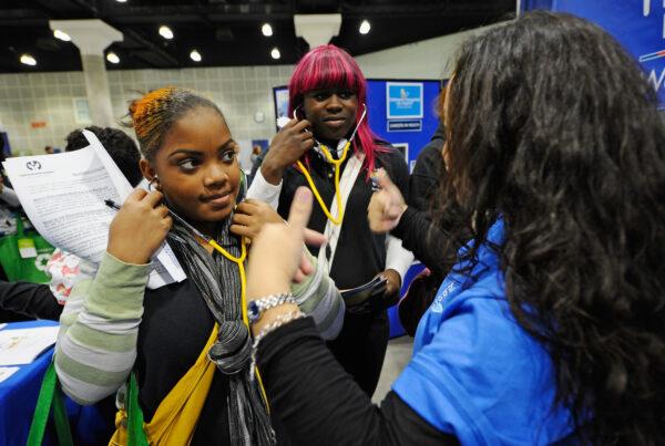 A transgender high school student (C) and classmate (L) visit the Children's Hospital Los Angeles booth during a college and career convention at the Los Angeles Convention Center in Los Angeles on Dec. 8, 2010. (Kevork Djansezian/Getty Images)