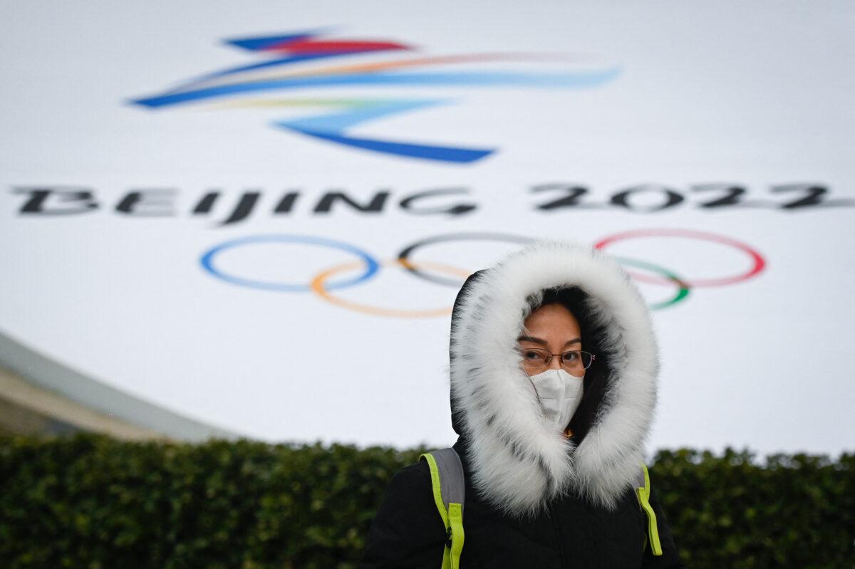 A woman walks past an installation promoting the Beijing 2022 Winter Olympic and Paralympic Games in Beijing on Jan. 19, 2022. (Wang Zhao/AFP via Getty Images)