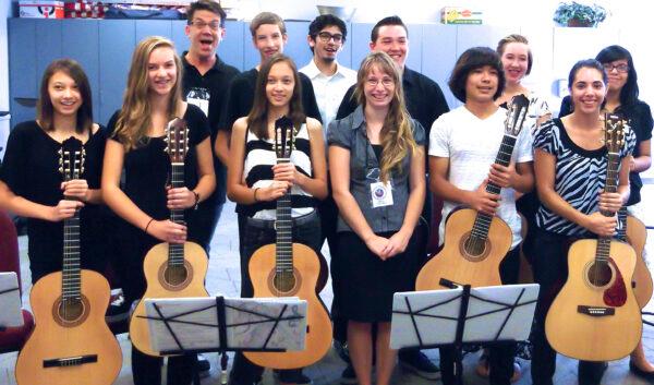 Students are awarded donated new guitars for successful participation at a Musical Mentors recital in Santa Ana, Calif. In the center front is volunteer mentor Cara, a local college student. Founder Duff Rowden is in the back row (L).  (Courtesy of Duff Rowden)