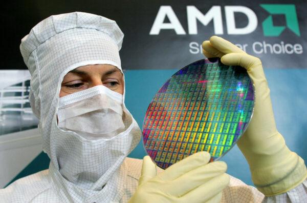 An AMD employee presents a 200-millimetre wafer of Advanced Micro Devices (AMD), the U.S. maker of computer chips, in Dresden, eastern Germany, on Oct. 24, 2006. (Norbert Millauer/DDP/AFP via Getty Images)