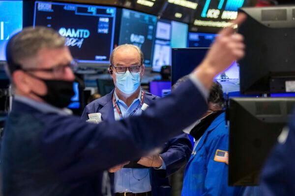 Trader David O'Day, center, works on the New York Stock Exchange trading floor on Jan. 20, 2022. (Courtney Crow/New York Stock Exchange via AP)