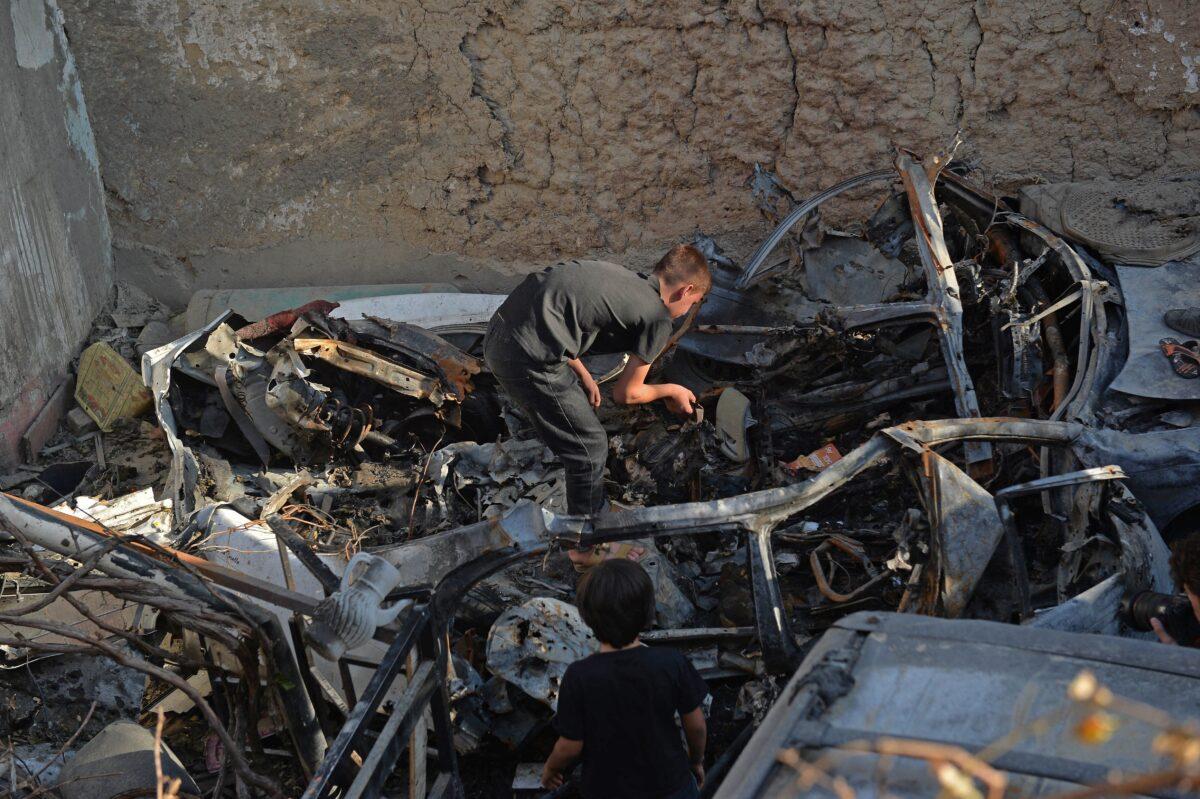 Boys inspect wreckage from a drone strike in Kabul, Afghanistan, on Sept. 18, 2021. (Hoshang Hashimi/AFP via Getty Images)