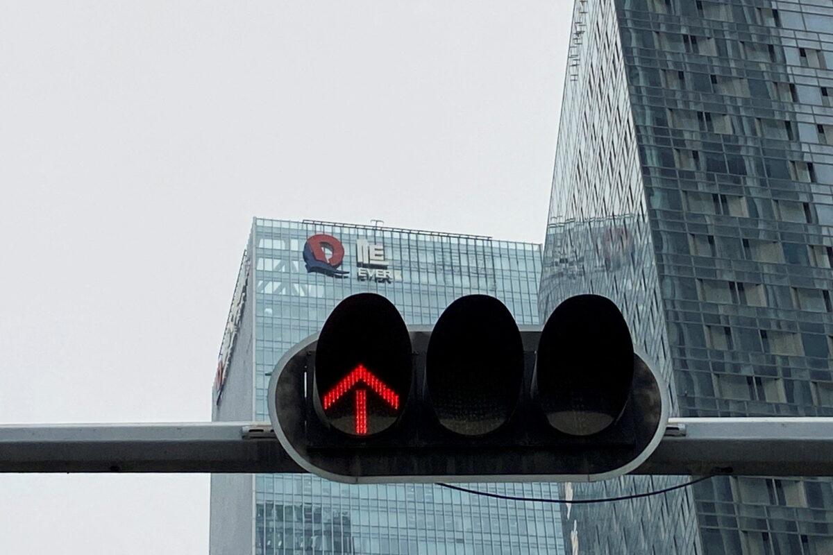 A partially removed company logo of China Evergrande Group is seen on the facade of its headquarters, near a traffic light in Shenzhen, Guangdong Province, China, on Jan. 10, 2022. (David Kirton/Reuters)