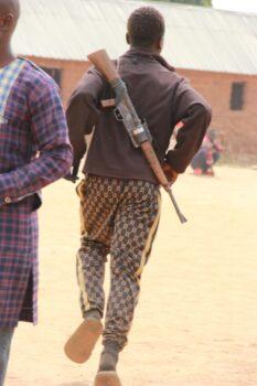 A civilian guard straps a homemade gun to his back in Ancha, Nigeria, on Jan. 12, 2022. (Masara Kim/The Epoch Times)