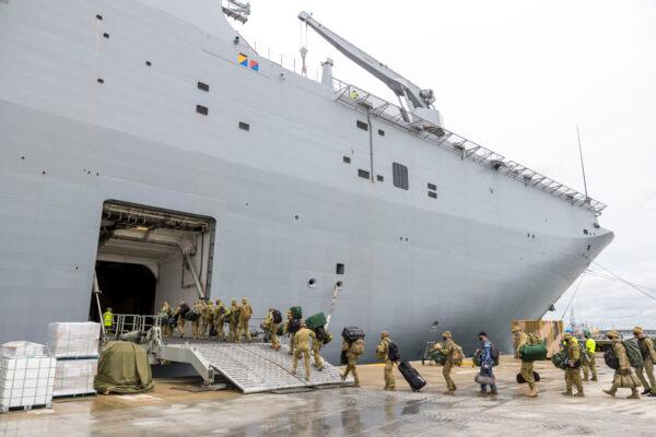 In this handout image provided by the Australian Defence Force, members of the Australian Defence Force board the HMAS Adelaide as they prepare to depart for an aid mission at the Port of Brisbane in Nuku'alofa, Tonga, on Jan. 20, 2022. (CPL Robert Whitmore/Australian Defence Force via Getty Images)