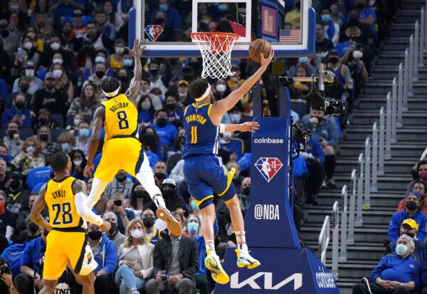 Klay Thompson #11 of the Golden State Warriors shoots and scores over Justin Holiday #8 of the Indiana Pacers during the first half of an NBA basketball game at Chase Center in San Francisco, on January 20, 2022. (Thearon W. Henderson/Getty Images)