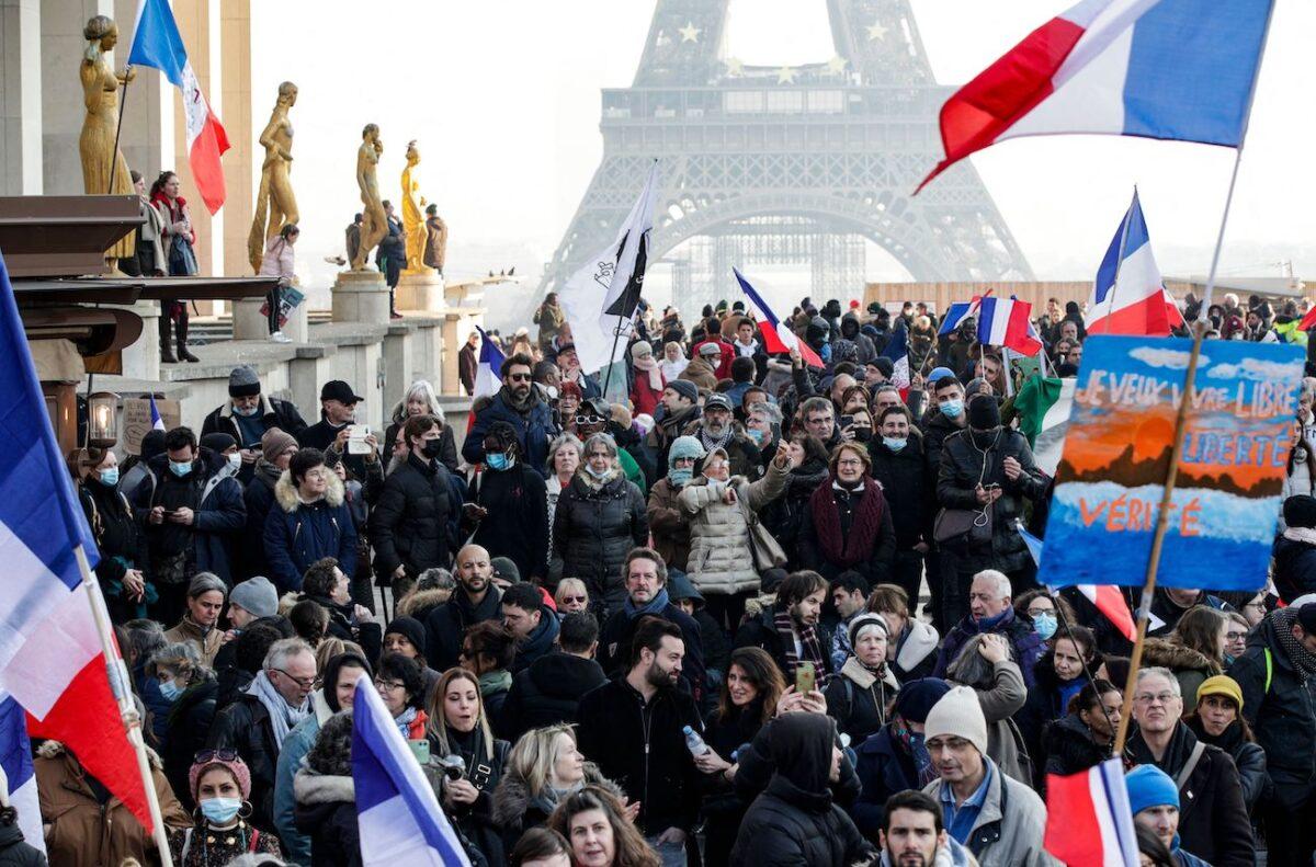 Protesters hold placards and French flags during a demonstration against the health pass and Covid-19 vaccines, on Trocadero plaza in Paris, on Jan. 15 2022. (Geoffroy van der Hasselt/AFP via Getty Images)
