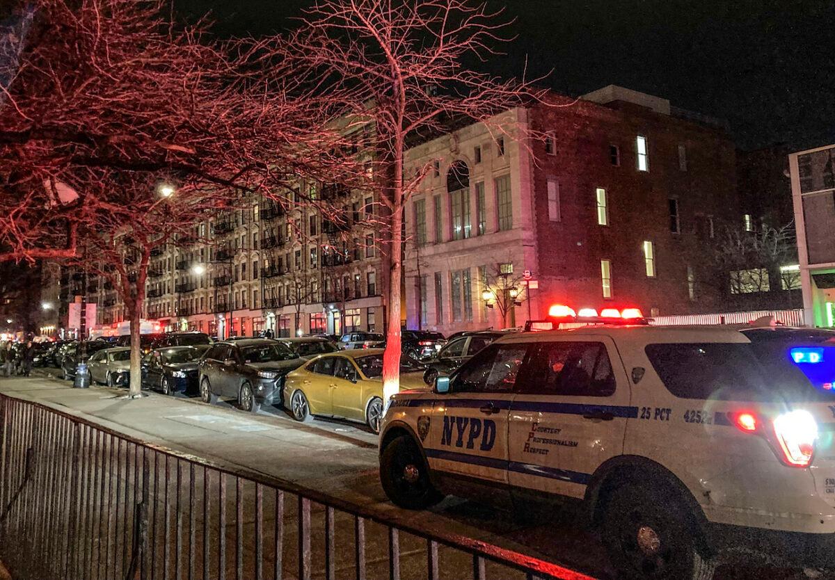 Police secure the scene outside a six story residential building, left, where two NYPD officers where shot responding to a domestic disturbance call in Harlem, N.Y., on Jan. 21, 2022. (Jennifer Peltz/AP Photo)