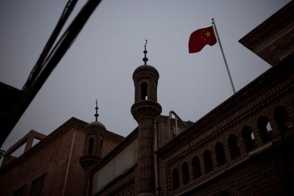 The Chinese national flag flies over a mosque in the old city in Kashgar, Xinjiang Uyghur Autonomous Region, China, on May 4, 2021. (Thomas Peter/Reuters)