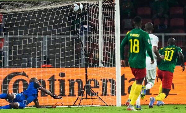 Comoros' goalkeeper Chaker Alhadhur, left, fails to stop a goal shot from Cameroon's Vincent Aboubakar, far right, during the African Cup of Nations 2022 round of 16 soccer match between Cameroon and Comoros at the Olembe stadium in Yaounde, Cameroon, on Jan. 24, 2022. (Themba Hadebe/AP Photo)