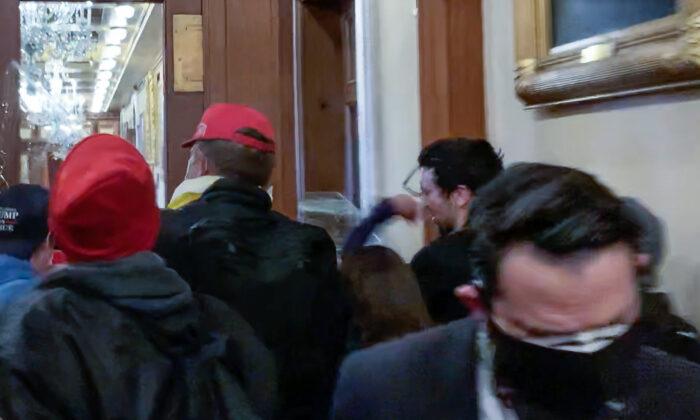 Ashli Babbitt punches rioter Zachary Alam in the face just before she climbs in a broken window leading to the Speaker's Lobby at the U.S. Capitol on Jan. 6, 2021. (Sam Montoya/Screenshot via The Epoch Times)