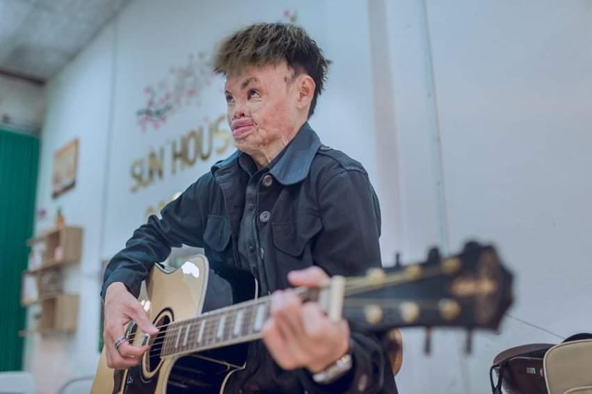 Hai playing guitar in his bakery shop. (Courtesy of <a href="https://www.facebook.com/sunhousecoffee/">Ngo Quy Hai</a>)