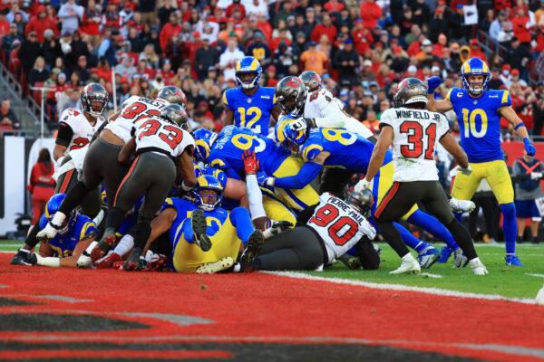 Matthew Stafford #9 of the Los Angeles Rams jumps over Tampa Bay Buccaneers and Los Angeles Rams players to score a touchdown in the third quarter in the NFC Divisional Playoff game at Raymond James Stadium, in Tampa, on Jan. 23, 2022. (Mike Ehrmann/Getty Images)